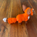 Orange Brown and White 3D printed Red Fox. Printed by Pilola. This picture shows the side view shown on a wooden background. 