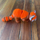 Orange Brown and White 3D printed Red Panda. Designed by Matmires and printed by Pilola. Shown on a wooden background With a side view