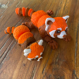 Orange Brown and White 3D printed Red Pandas. Designed by Matmires and printed by Pilola. Both sizes shown together on a wooden background 
