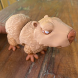 3D printed brown Capybara. Designed by Matmires and printed by Pilola. Showing a close up of the side and face on a wooden background