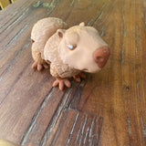 3D printed cute brown Capybara. Designed by Matmires and printed by Pilola. Showing close up of the face and body on a wooden background